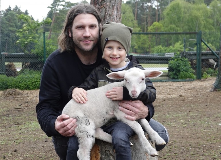 Torsten Frings, und sein Sohn Luke mit dem kleinen Leineschafweibchen Maxi. Foto: Serengeti-Park Stiftung