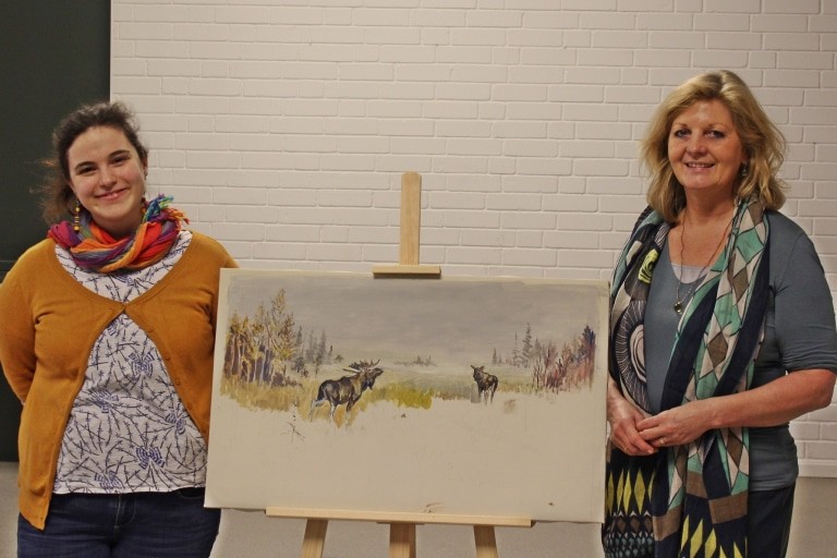 Lea Friederike Schott (Kuratorin Naturkunde) und Prof. Dr. Heike Düselder (Museumsleiterin) (v. l.) zeigen ein Bild des Künstlers Jürgen Freiherr v. Wolff aus den siebziger Jahren, das aufgrund seines Todes unvollendet blieb. Foto: Museum Lüneburg