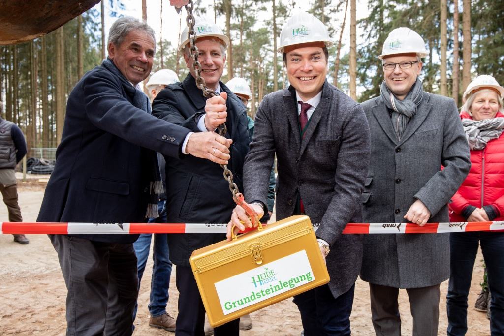 Norbert Tietz (von links), Landrat Rainer Rempe, Alexander Tietz und Hanstedts Samtgemeindebürgermeister Olaf Muus, lassen den Grundstein in die Erde ein. Foto: Adrian Fohl