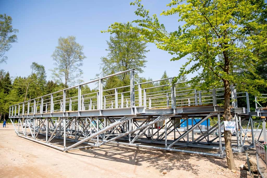 Im Anlieferungsbereich werden die einzelnen Brückenteile, Pfosten und Gehwegbeläge vormontiert, bevor sie per Kran auf die Fundamente gesetzt werden. Foto: Thomas Ix