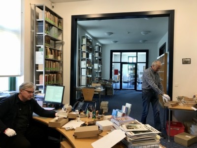 Christoph Neddens und Reinhard Röpke sichten historisches Fotomaterial aus dem Archiv Menzendorf. Foto: Deutsches Pferdemuseum e.V.